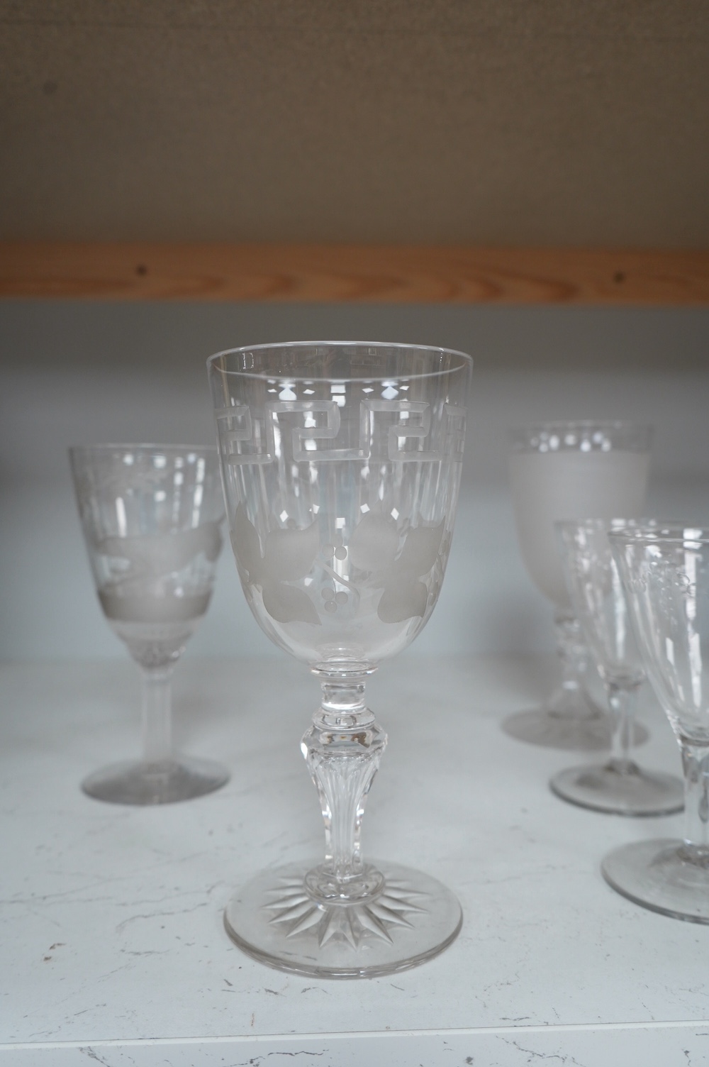 A Victorian Stourbridge wine glass, the bowl engraved with a running rabbit, together with six other glasses, tallest 19cm (7). Condition - good